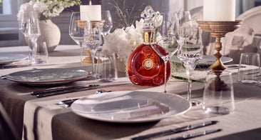 Bouteille de cognac Louis XIII mise en avant au cœur d’un dressage raffiné, symbole de luxe, de prestige et d’art de vivre